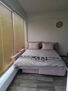 ein Schlafzimmer mit einem rosa Bett und einer Uhr an der Wand in der Unterkunft Apartment Maliva in Weliko Tarnowo + 10 Fotos