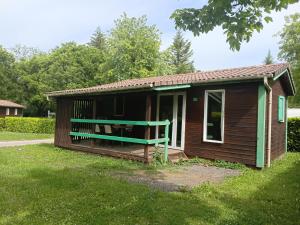 a small cabin with a porch and a bench at Camping Onlycamp Les Bords de Lyonne in Saint-Jean-en-Royans +6 photos