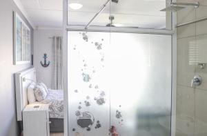 a bathroom with a glass shower door with a crib at A Lighthousee delight in Swakopmund
