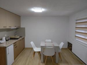 a kitchen with a white table and white chairs at Apartment Matej in Kruševo