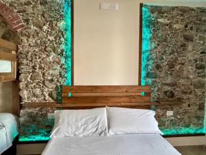 ein Schlafzimmer mit einem Bett und einer Steinwand in der Unterkunft Gemma Maris in Sapri