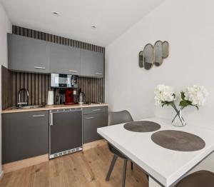 a kitchen with a table and a white counter top at Prime Host Sophie Apartments in Karlsruhe