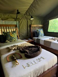 a bedroom with two beds and a sign that says vacation at Hemingway's Luxury Tented Camp in Paraa