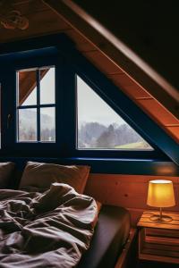 a bedroom with a bed and a lamp and two windows at Tu W Dolinie in Ropica Górna