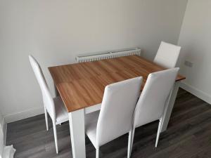 a dining room table with white chairs around it at Aries de Baldock in Canterbury +4 photos