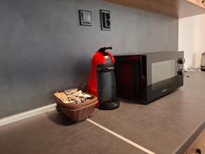 Ein rotes Haushaltsgerät steht neben einer Mikrowelle und einem Korb. in der Unterkunft Apartment Maliva in Weliko Tarnowo