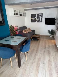 a living room with a table and a couch at Glycine in Orléans