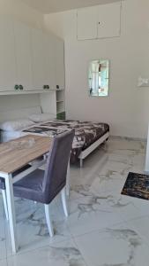 a room with a bed and a table and a chair at Skizzo residence in Santa Maria degli Angeli