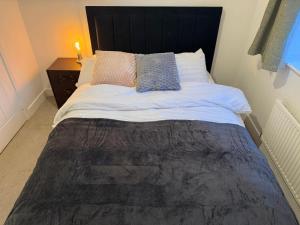 a bedroom with a large bed with a black headboard at Aries de Baldock in Canterbury