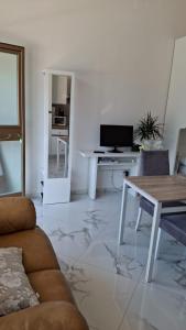 a living room with a couch and a table at Skizzo residence in Santa Maria degli Angeli +18 photos