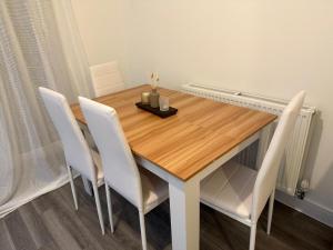 a dining room table with white chairs around it at Aries de Baldock in Canterbury