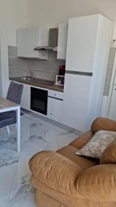 a kitchen with a brown couch in a room at Skizzo residence in Santa Maria degli Angeli
