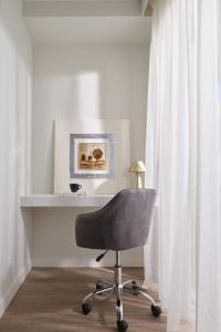 a desk with a chair next to a window at Civitel Attik Rooms & Suites in Athens