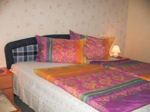 a bed with colorful sheets and pillows on it at Ferienhaus Bohne in Rubitz +3 photos
