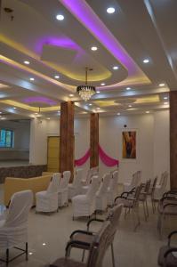 a room with white chairs and purple lighting at Hotel Vijanta Banquet in Sasarām