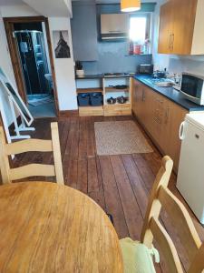 a kitchen with a table and chairs and a refrigerator at The Courtyard Hideout in Hereford