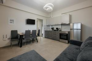 a living room with a table and a kitchen at Soro Rooms in Kanali
