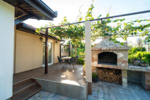 a patio with a stone fireplace and a table at Villa Bella in Mostar