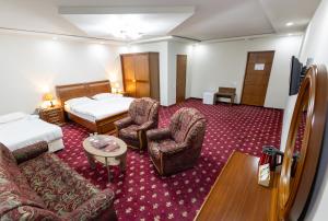 a hotel room with a bed and two chairs at Gyumri Hotel in Gyumri
