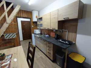 a kitchen with wooden cabinets and a counter top at Chatička For Funny in Horní Slavkov