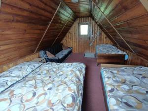 a room with two beds in a wooden cabin at Chatička For Funny in Horní Slavkov