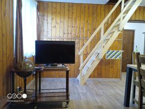 a living room with a television and a staircase at Chatička For Funny in Horní Slavkov