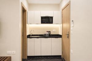 a small kitchen with a sink and a microwave at Stay Inn 51 Hotel Zayed in Sheikh Zayed