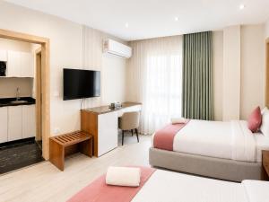 a hotel room with two beds and a flat screen tv at Stay Inn 51 Hotel Zayed in Sheikh Zayed