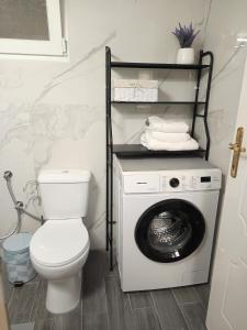 a bathroom with a toilet and a washing machine at Elenis Garden View Apartment in Perea +16 photos