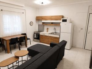 a living room with a couch and a table and a kitchen at Elenis Garden View Apartment in Perea