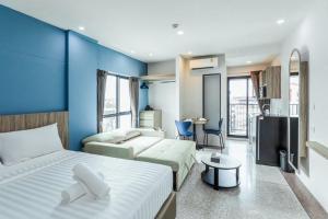 a bedroom with two beds and a blue wall at ABC@48 Hotel & Service Apartment in Bangkok +28 photos