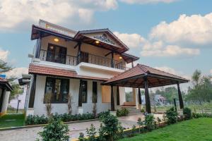 a house with two gazebos in front of it at Nadhima Villas in Kumbakonam