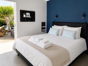 a bedroom with a large bed with towels on it at Villa Claus - Private Pool Oasis in Puerto Calero in Puerto Calero
