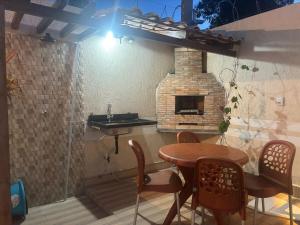 a patio with a table and a brick oven at Casa espaçosa em Itacimirim com piscina e churrasqueira! in Camaçari