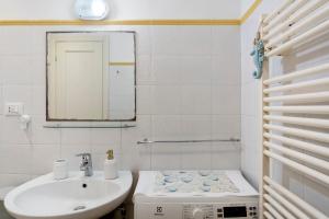 a white bathroom with a sink and a mirror at Fontanine House in Rapallo +24 photos