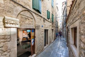 an alley in an old city with people walking down it at Grgur Ninski Rooms in Split