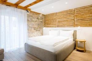 a bed in a room with a brick wall at Grgur Ninski Rooms in Split