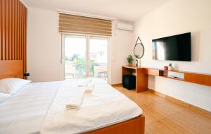 a bedroom with a large bed and a television at Lux Ariana in Donji Štoj