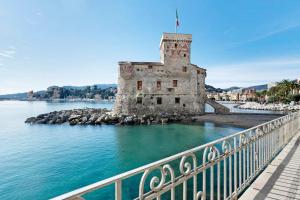 an old castle in the water next to a bridge at Fontanine House in Rapallo