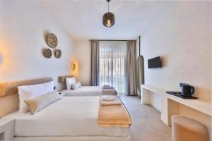 a hotel room with two beds and a couch at yazz inn in Kaş