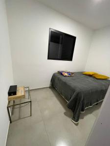 a bedroom with a bed with a flat screen tv on the wall at Apartamento Tranquilo e Aconchegante in Carmo do Rio Claro
