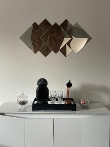 a white counter with glasses and lights on a wall at Apartamento Tranquilo e Aconchegante in Carmo do Rio Claro