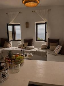 a living room with two beds and a table with a bowl of fruit at Agrià XVII Mani Stone Tower in Kotráfion +57 photos