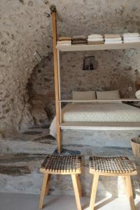 a bedroom with a bunk bed and two wooden benches at Agrià XVII Mani Stone Tower in Kotráfion