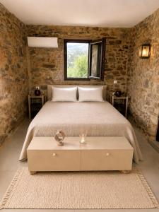 a bedroom with a bed and a window at Agrià XVII Mani Stone Tower in Kotráfion