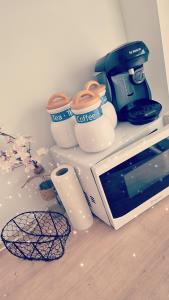 a counter with cups and a coffee maker and a microwave at Le cocon en ville in Limoux