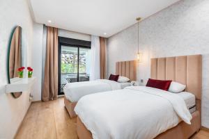 a hotel room with two beds and a window at Seaside Pool View 3BR Apt with 2 Balconies in Tangier