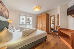 a bedroom with a large bed and a desk at Chalet Perauer in Mayrhofen