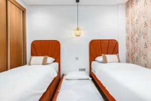 two beds sitting next to each other in a room at Seaside Pool View 3BR Apt with 2 Balconies in Tangier