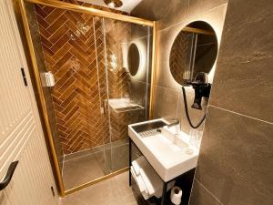 a bathroom with a sink and a shower with a mirror at The Tram Karakoy in Istanbul +56 photos
